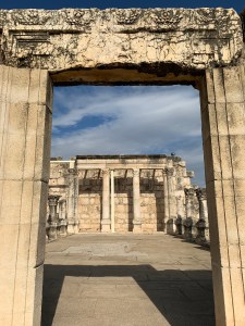 Looking through doorway of white stone into the roofless remains of a synagogue