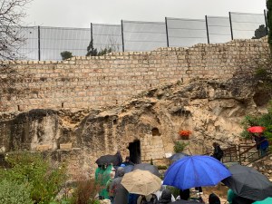 A rocky wall with a doorway to a tomb
