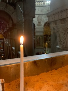 Single candle burning in church