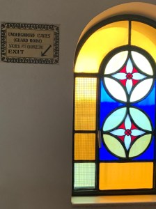 Sign pointing to dungeon next to a stained glass window