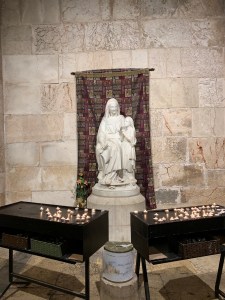 White statue of a woman seated with a young girl standing beside her