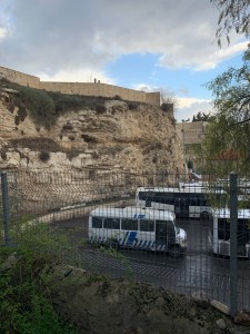 Buses parked next to a rocky cliff