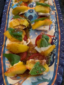 Tray with sliced peaches, tomatoes and mozzarella cheese